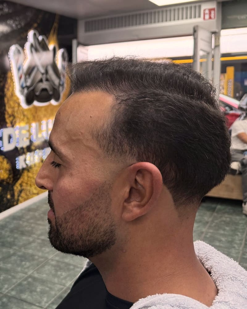 Taper fade met een strak bijgewerkte baard, zijaanzicht